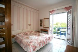 a bedroom with a bed and a balcony at Ionio Gastronomy Suites in Ammoudia