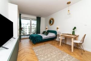 1 dormitorio con cama, mesa y escritorio en Pobookowane Barbary DeLux Old Town, en Gdansk