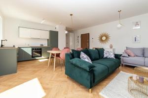 uma sala de estar com um sofá verde e uma cozinha em Pobookowane Barbary DeLux Old Town em Gdansk