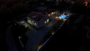 an aerial view of a house at night with a swimming pool at Nova Apartments in Poljica