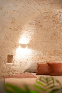 um quarto com uma cama com uma parede de pedra em Monte Adamello - dimora nei trulli em Alberobello
