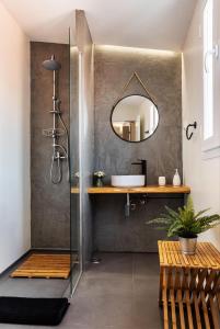 a bathroom with a shower with a sink and a mirror at Alfar Story - Évora House in Évora