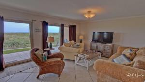 sala de estar con sofá, sillas y TV en Seagull 101 Condominium Condo, en South Padre Island