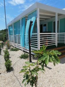 a house with a surfboard in front of it at White-Pearl Mobile-Home in Jezera