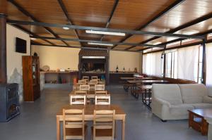 ein Zimmer mit Tischen und Stühlen und ein Zimmer mit Fenstern in der Unterkunft Rural Reillo Alojamientos Rurales in Reíllo