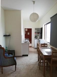 a kitchen and dining room with a table and chairs at 5th floor apartment with city view in Athens