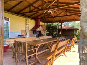 un patio con grande tavolo e sedie in legno di Maritsa's Rooms a Stavros