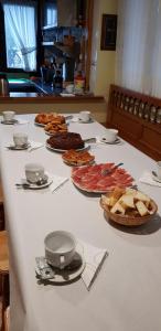 una mesa blanca con platos de comida. en Hotel Alina, en Cangas del Narcea