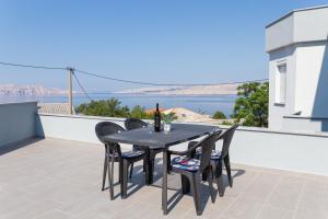 a table and chairs on a balcony with a view of the water at Apartments Luka in Senj