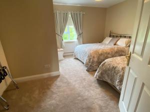 a bedroom with two beds and a window at Quignalegan House in Ballina