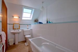 a bathroom with a tub and a toilet and a sink at Easter Corrie Cottages in Ballindalloch +98 photos