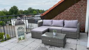 a patio with a couch and a table on a balcony at Nachtquartier Münster in Münster