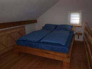 Una cama con sábanas azules en una habitación pequeña. en Apartment Schritte, en Hinterweiler