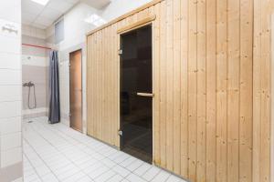 korytarz z drewnianymi drzwiami w łazience w obiekcie AL-DOM apartamenty Olymp 109 w Kołobrzegu