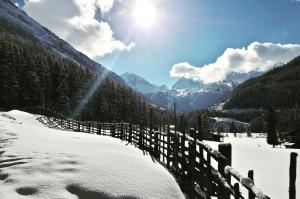 a snow covered valley with a fence and mountains at Ferienwohnung Alpenheim in Tux