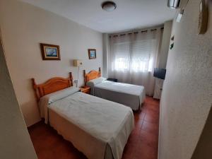 Habitación de hotel con 2 camas y TV en Hostal Costa Rica, en San José