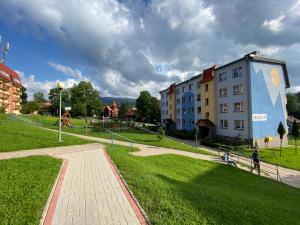 a building with a mural on it next to a park at APARTAMENT MARTYNKA in Szklarska Poręba