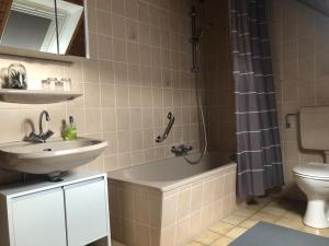 La salle de bains est pourvue d'une baignoire, d'un lavabo et de toilettes. dans l'établissement FeWo Stubenhocker, à Pleisweiler-Oberhofen