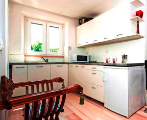 een keuken met witte kasten en een bank erin bij EXCELSIOR Apartments Rovinj in Rovinj