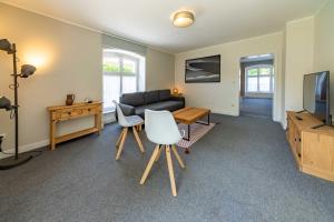 a living room with a couch and a table and a television at Edelburg 3 - Ferienwohnung in Hemer