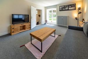 a living room with a television and a table at Edelburg 3 - Ferienwohnung in Hemer