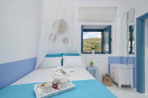 a blue and white bedroom with a bed and a window at Apanemo in Kóronos
