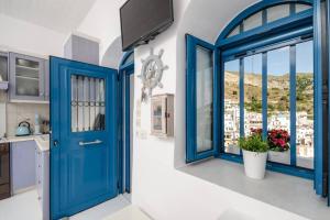 a blue door in a kitchen with a window at Apanemo in Kóronos