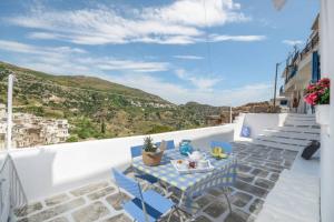 a table and chairs on a balcony with a view at Apanemo in Kóronos