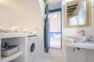 a white bathroom with a washing machine and a sink at Apanemo in Kóronos +21 photos