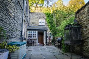 an alley with a brick building and a house at Shibden Hall View in Halifax