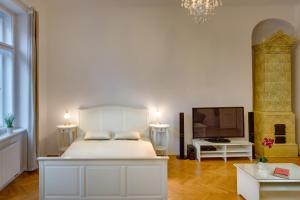 1 dormitorio con 1 cama blanca y TV en Karlova 24 - Old Town Apartment en Praga