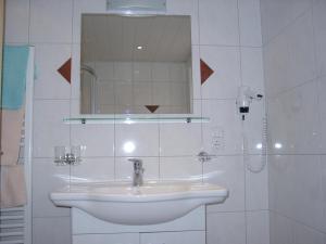 a white bathroom with a sink and a mirror at Kammerlandhof in Hippach