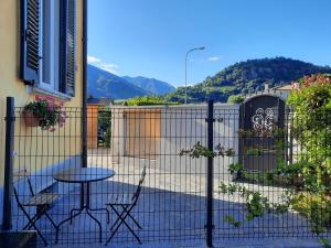 eine Terrasse mit einem Tisch, Stühlen und einem Zaun in der Unterkunft Apartment Alina in Lamone