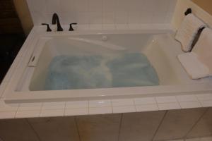a bath tub filled with water in a bathroom at The Fields of Eden Inn in Eden