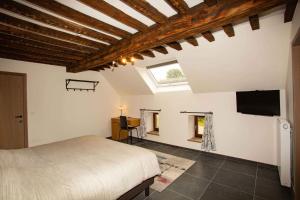 1 dormitorio con 1 cama y TV de pantalla plana en B&B Hotel Ferme des Templiers nabij Durbuy, eigen laadpalen en Somme-Leuze