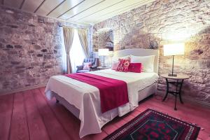 a bedroom with a bed and a stone wall at Macaron Konagi in Ayvalık