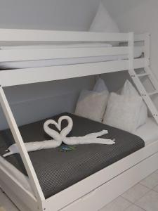 een wit stapelbed met een wit hart erop bij FeWo Marussia in Rust