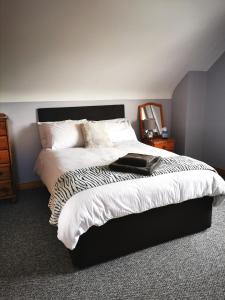 a bedroom with a bed with a black and white comforter at The Tree-house B&B in Ballymena