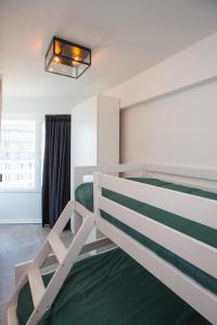 een slaapkamer met een stapelbed en een groen tapijt bij Ostend Seasight Luxury Apartment with free private parking in Oostende