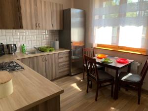 a kitchen with a small table with chairs and a counter at Pokoje Zalesie in Ostrowo