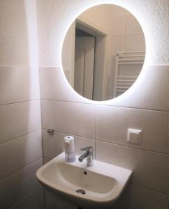 a bathroom with a sink and a mirror at Wohnung Luv - Alte Schule in Glowe +15 photos