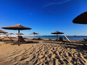 a beach with chairs and umbrellas and the ocean at Casa Del Mar in Primorsko