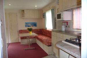 una pequeña cocina y sala de estar en una caravana en Altogold Swiss Holidays At Manor Farm 5* en Interlaken