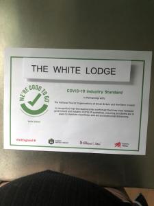 una señal que dice la cabaña blanca en una pared en The White Lodge, en Great Yarmouth