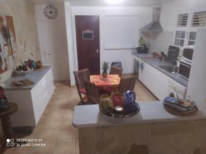 eine kleine Küche mit einem Tisch und Stühlen in einem Zimmer in der Unterkunft Villa Emmanuel le Plaisir des Vacances in Sainte-Luce