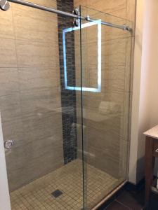 a shower with a glass door in a bathroom at Wyndham Garden River Walk Museum Reach in San Antonio