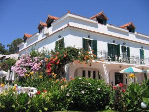 a white building with flowers in front of it at Tara Beach Hotel in Skala Kefalonias
