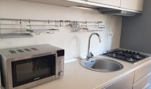 a kitchen with a sink and a microwave at Apartament Deea in Mamaia Nord