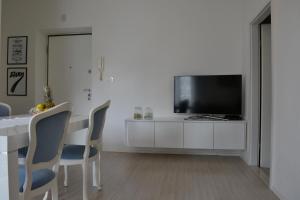 a white living room with a table and a television at Apartment Seven in Split