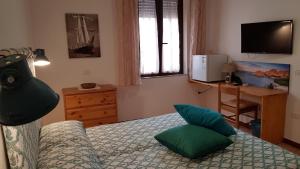 a bedroom with a bed with green pillows and a desk at Campo Base in La Maddalena